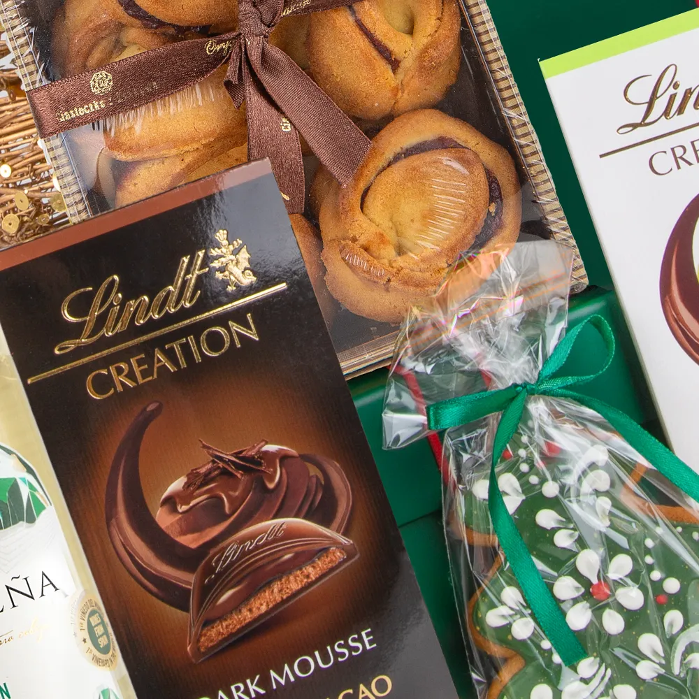 Zbliżenie na Krakowskie kruche ciasteczka z różą oraz Lukrowany piernik choinka. Obok widoczna Czekolada Lindt Creation Dark Mousse.